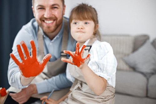 11 - STOCK - girl-with-down-syndrome-her-father-painted-hands-red-colour.jpg